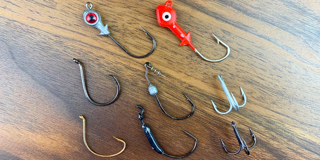 Assorted fishing hooks arranged by size and type for different fish species.