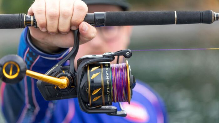 Angler casting fishing line into lake using lightweight rod.