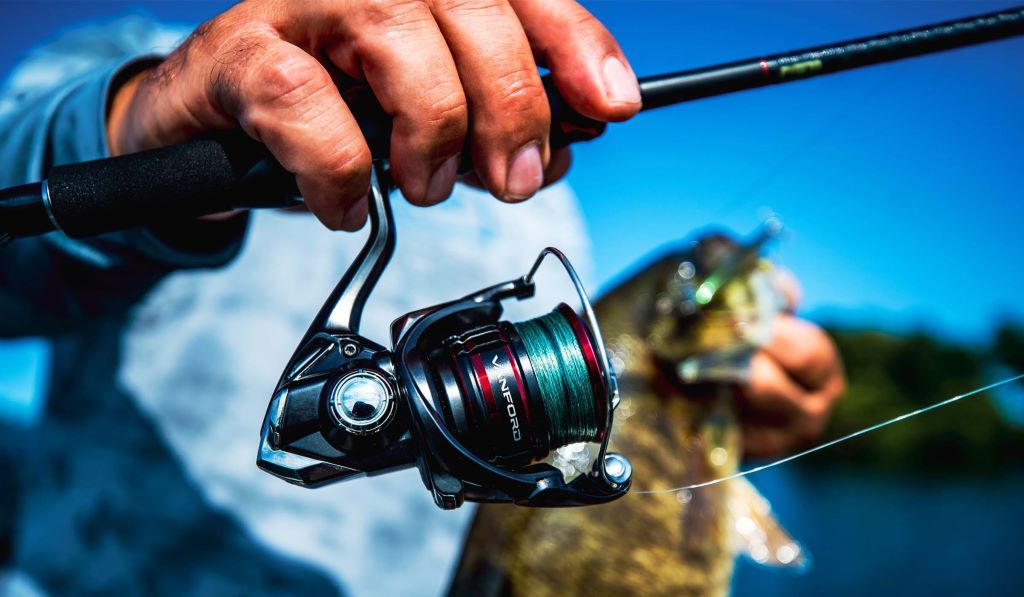 Angler using smooth baitcasting reel while fishing in lake.