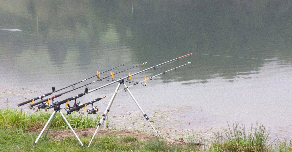 Colorful kids fishing rod set placed beside small tackle box and bait.