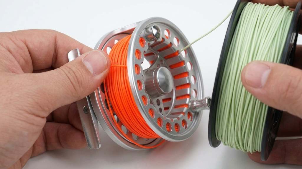 Angler inspecting black Maximumcatch Maxcatch Eco fly reel on fly rod seat.