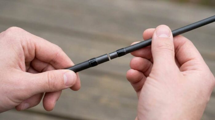 Angler joining four-piece graphite sections of SF fly fishing rod using alignment dots.